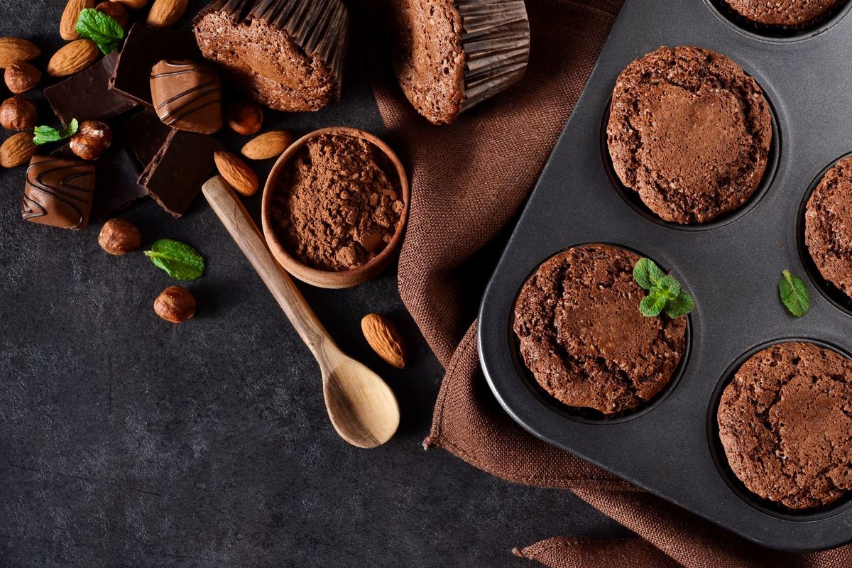 Chocolate muffins, brownies with nuts and chocolate on a black background